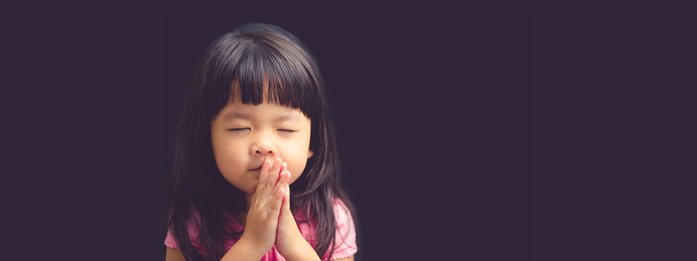 Picture of a little girl with folded hands praying